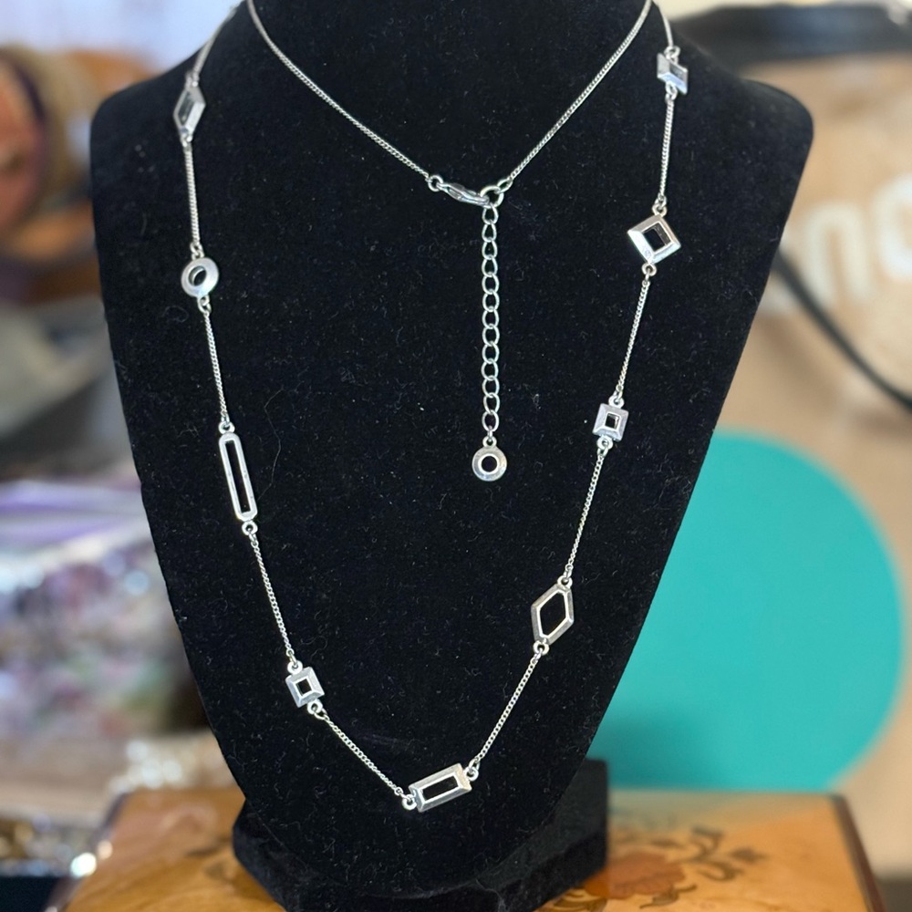 32-34” silver tone layering necklace with geometric shapes on it.